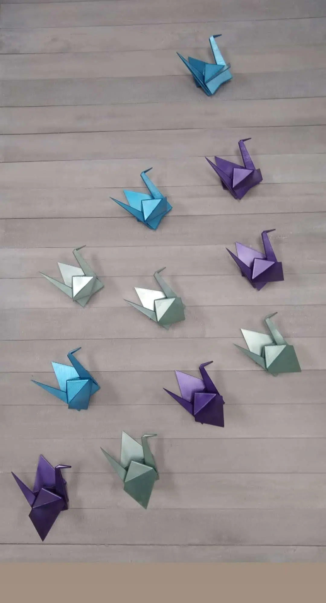 origamis coloridos sobre ripas de concreto